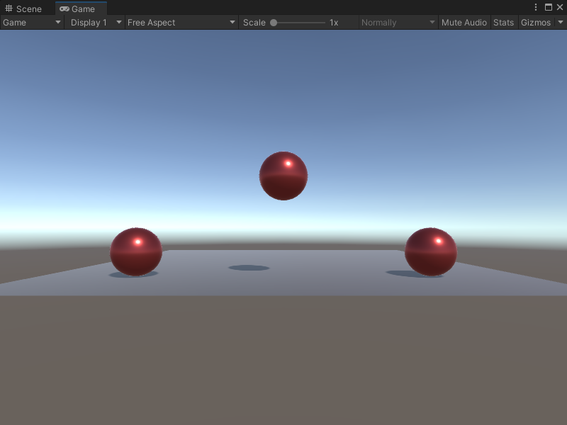 An image of the Game view. Three red spheres are on top of a grey plane, with the middle sphere lifted into the air.